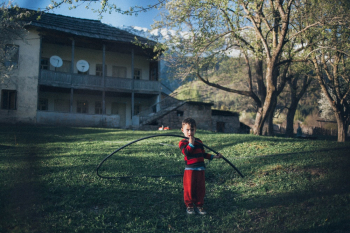 Boy Wearing Red and Black Shirt Holding Black Hose Boy Wearing Red and Black Shirt Holding Black Hose