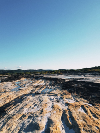 Brown and Black Rocky Terrain Under Blue Sky Brown and Black Rocky Terrain Under Blue Sky