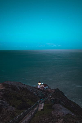 brown and white house on cliff in front of sea brown and white house on cliff in front of sea