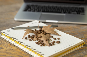 Brown Leaf and Coffee Beans On A Notebook
