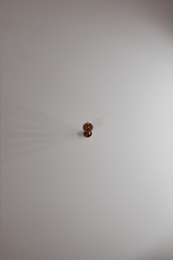 Brown Push Pin on White Surface Brown Push Pin on White Surface