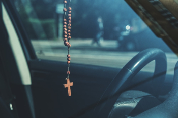 Brown Rosary Dangling on Car's Rear View Mirror Brown Rosary Dangling on Car's Rear View Mirror