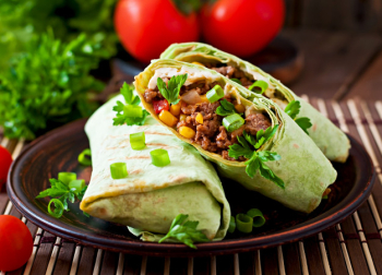 Burritos wraps with minced beef and vegetables on a wooden surface Free Photo
