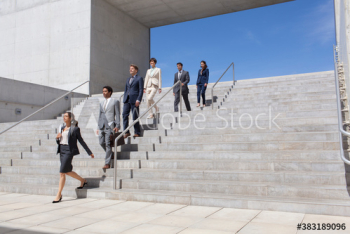 Business people descending sunny stairs Business people descending sunny stairs