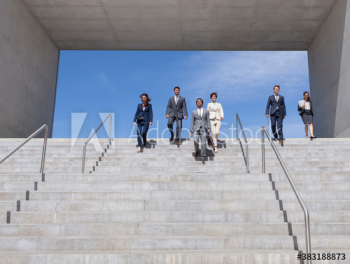 Business people descending sunny steps Business people descending sunny steps