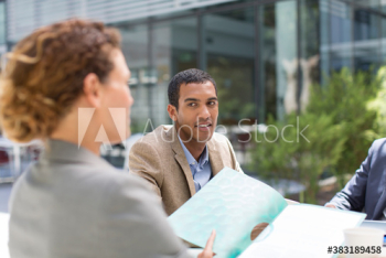 Business people discussing paperwork outside Business people discussing paperwork outside