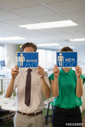 Business people holding men and women bathroom signs Business people holding men and women bathroom signs