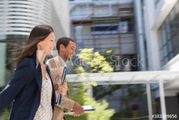 Business people running outside office building Business people running outside office building