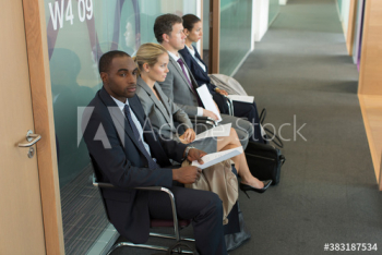 Business people waiting for job interview in office corridor Business people waiting for job interview in office corridor