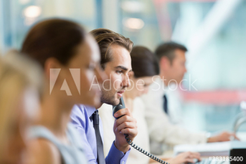 Businessman talking on telephone in office Businessman talking on telephone in office
