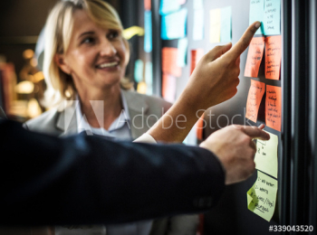 Businesspeople planning tasks with sticky notes