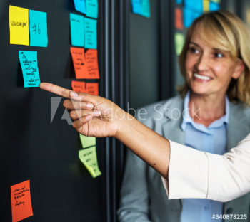 Businesspeople planning tasks with sticky notes