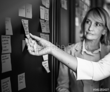 Businesspeople planning tasks with sticky notes