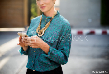 Businesswoman standing and using mobile phone Businesswoman standing and using mobile phone