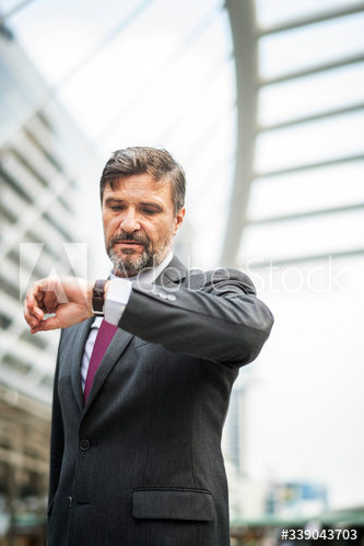 Busy businessman checking his watch Busy businessman checking his watch