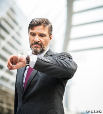 Busy businessman checking his watch Busy businessman checking his watch