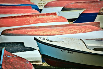 canoe boats on sand during daytime canoe boats on sand during daytime