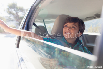 Carefree boy riding in car with hand out window