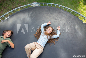 Carefree kids laying on trampoline
