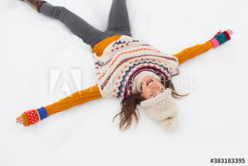 Carefree young woman making snow angel
