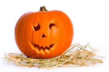 Carved face in pumpkin on a bed of straw