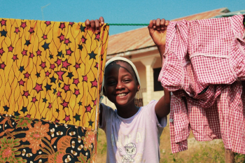 Child Smiling Holding Hanging Line with Clothes Child Smiling Holding Hanging Line with Clothes