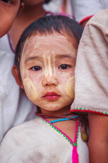 child with beige face paint child with beige face paint