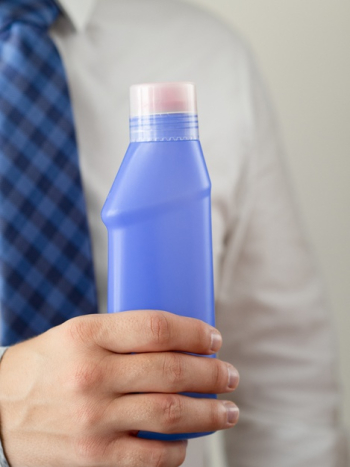 Close-up hand holding blue detergent bottle mock-up Free Photo