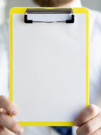 Close-up man showing a clipboard mock-up Free Photo