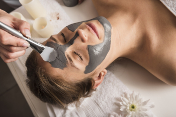 Close-up of a beautician applying face mask on woman's face Close-up of a beautician applying face mask on woman's face