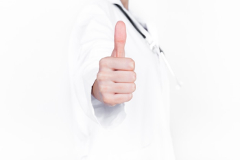 Close-up of a doctor's hand gesturing thumbs up