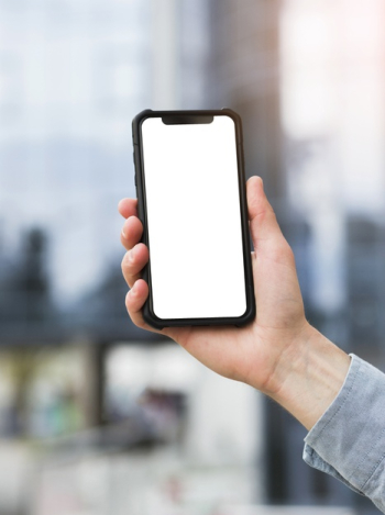 Close-up of businessman's hand holding mobile phone with white screen display Free Photo