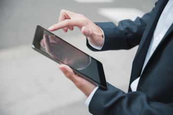 Close-up of businessman's hand using digital tablet Free Photo