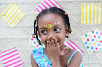 Close-up Photo of Smiling Girl Covering Mouth