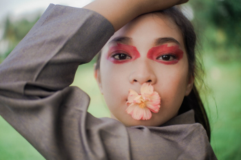 Close-up Photo of Woman with Flower on Her Mouth