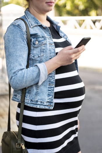 Close-up pregnant woman with smartphone outdoors Free Photo