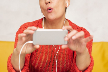 Close-up senior woman watching music videos Free Photo