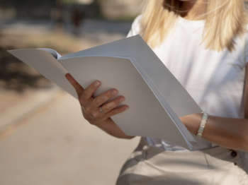 Close-up woman holding a mock-up magazine Free Photo