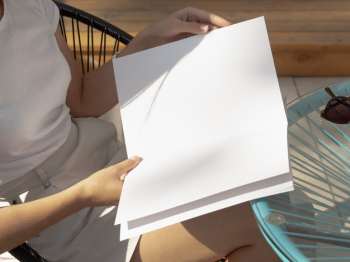 Close-up woman holding a mock-up magazine Free Photo