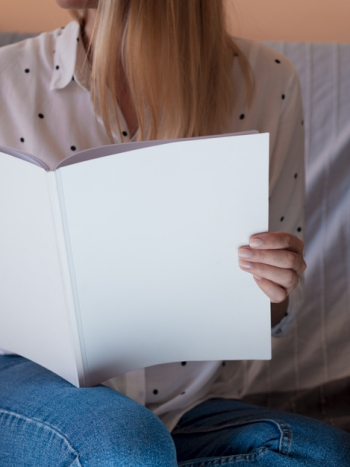 Close-up woman holding a mock-up magazine Free Photo