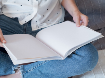 Close-up woman holding a mock-up magazine Free Photo