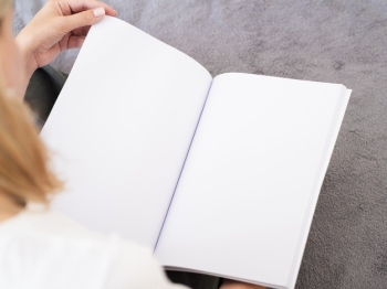 Close-up woman holding a mock-up magazine Free Photo