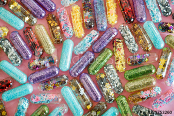 Closeup of glittery shimmery shiny pills capsule background Closeup of glittery shimmery shiny pills capsule background