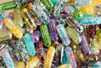 Closeup of glittery shimmery shiny pills capsule background Closeup of glittery shimmery shiny pills capsule background
