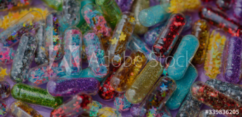Closeup of glittery shimmery shiny pills capsule background Closeup of glittery shimmery shiny pills capsule background