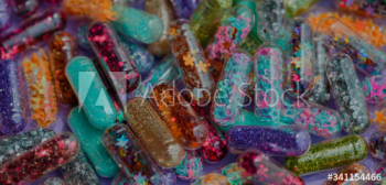 Closeup of glittery shimmery shiny pills capsule background Closeup of glittery shimmery shiny pills capsule background