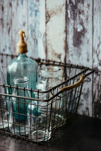 Collection of bottles in metal mesh basket Collection of bottles in metal mesh basket