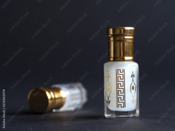 Concentrated perfume in a mini bottle on the black table