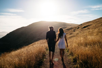 couple walking near mountain range couple walking near mountain range