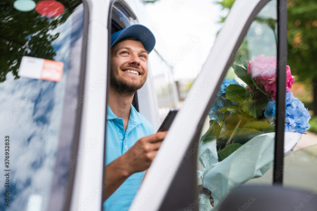 Courier inside the white van during flowers delivery is waiting for a client